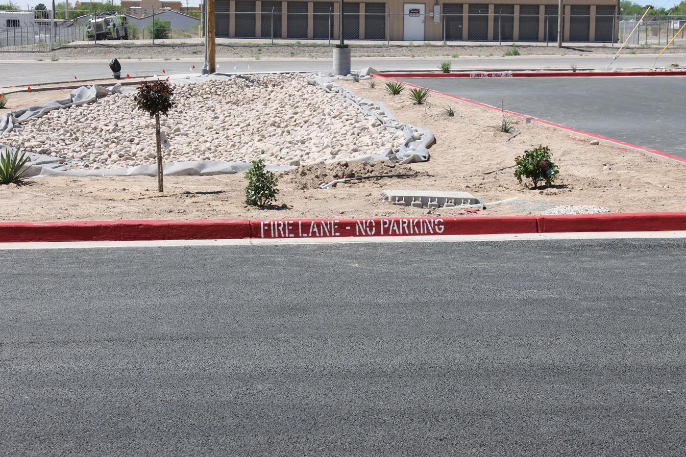 Fresh red fire lane curb painting along a parking area